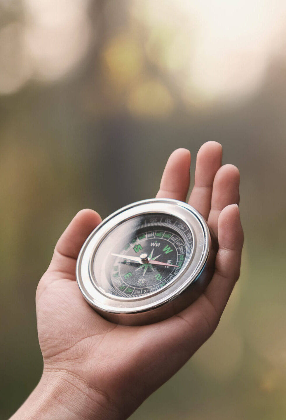 Navigator man's hand holding a reliable circle compass while he